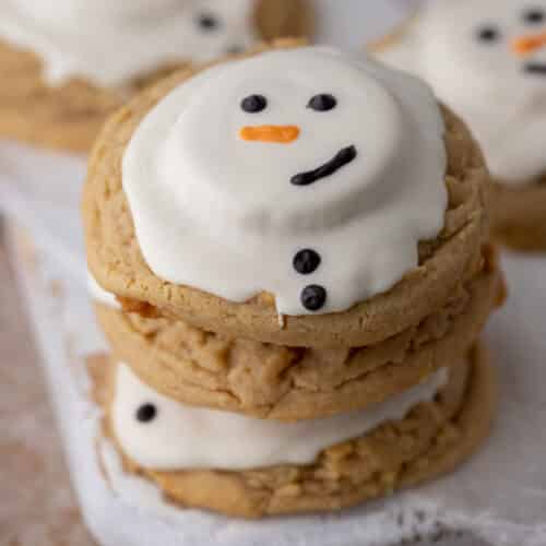 angled overhead shot of three melted snowman peanut butter cookies