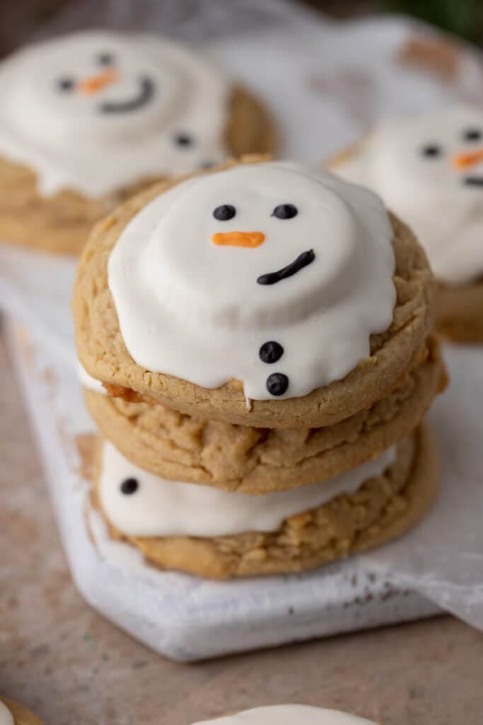 angled overhead shot of three melted snowman peanut butter cookies