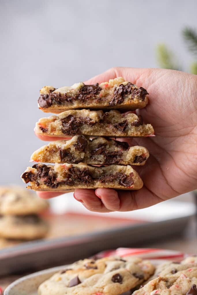a hand holding up multiple peppermint chocolate chip cookies