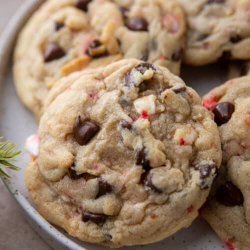 close up of a peppermint chocolate chip cookie with others behind it on a plate