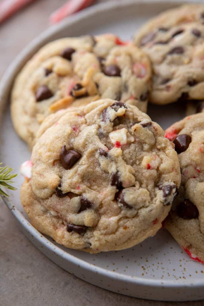 close up of a peppermint chocolate chip cookie with others behind it on a plate