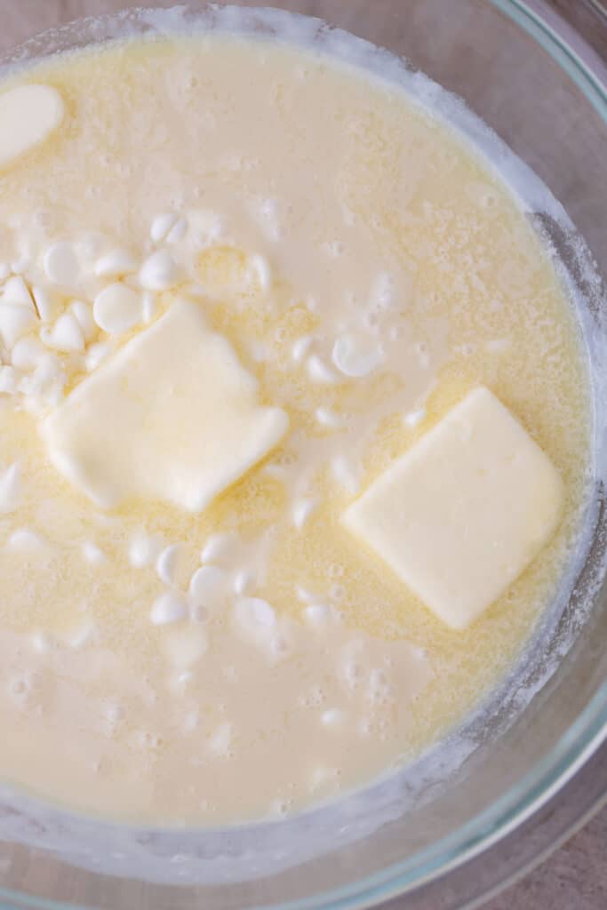 white chocolate, butter, and sweetened condensed milk being melted into a bowl
