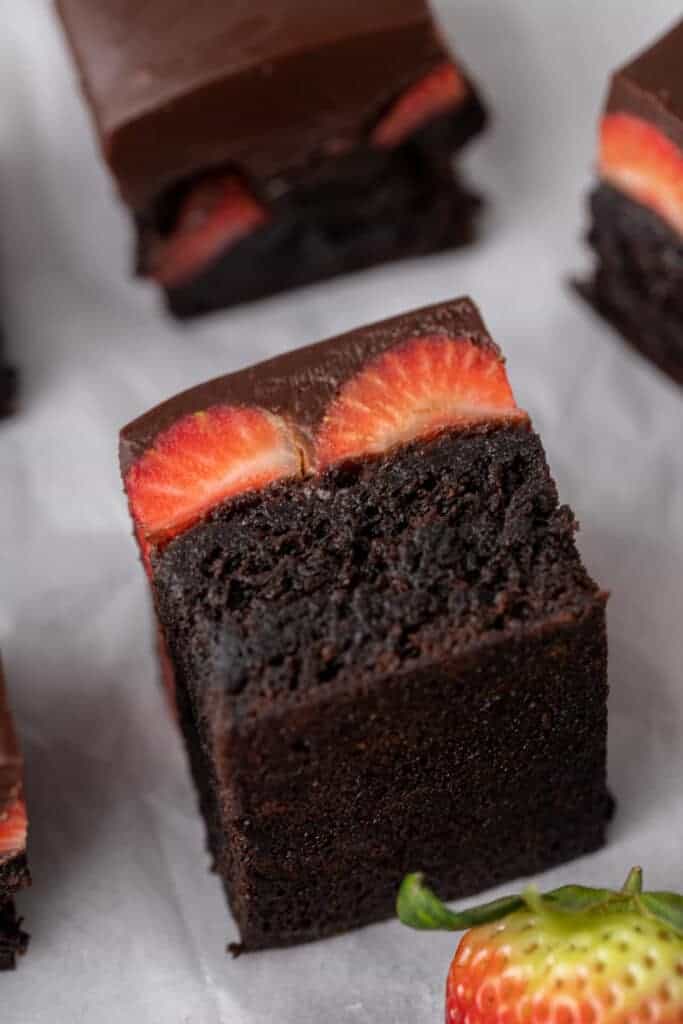 Chocolate covered strawberry brownie square showing a thick fudgy brownie base topped with chocolate ganache and fresh strawberry slices