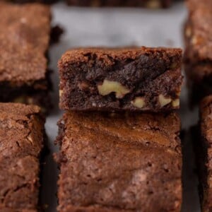 a fudge walnut brownie flipped on its side with other brownies around it.