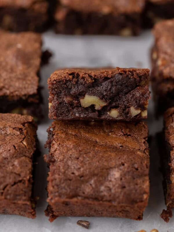 a fudge walnut brownie flipped on its side with other brownies around it.