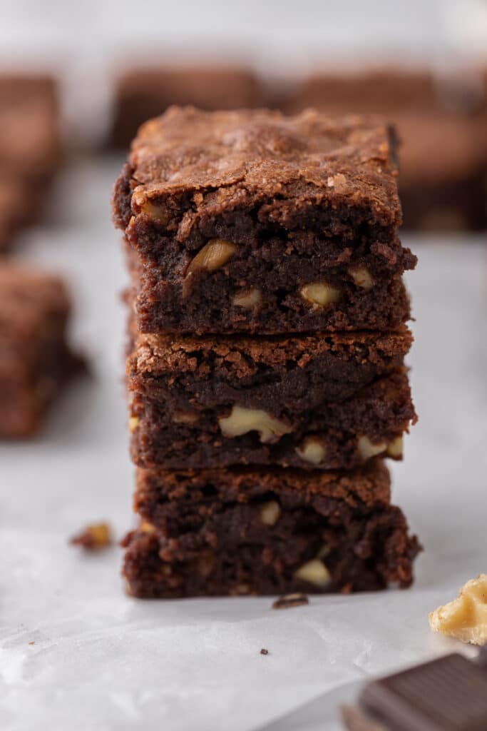 three fudge walnut brownies stacked on top of each other