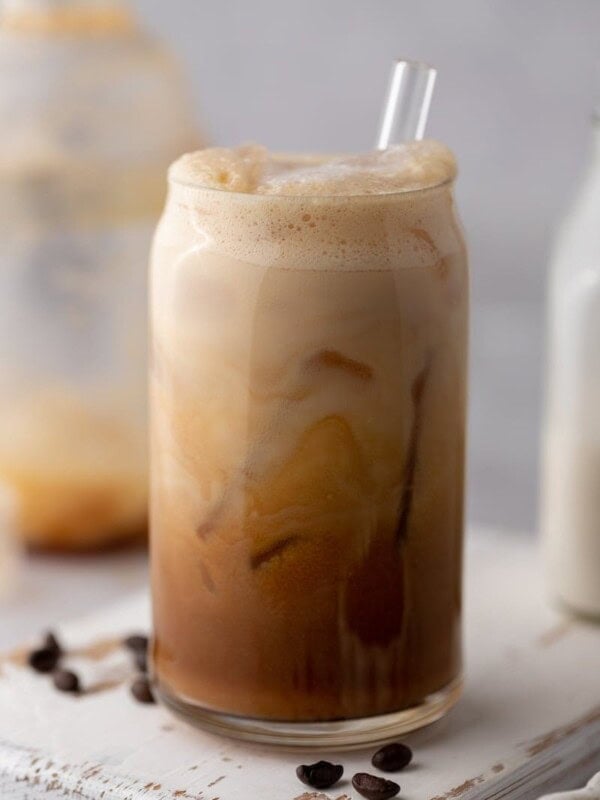 an iced hazelnut oatmilk shaken espresso starbucks drink in a glass with a straw