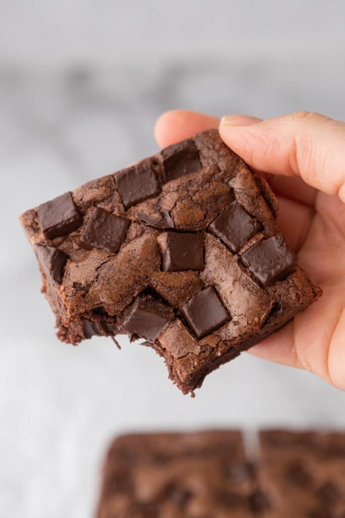 a square of the starbucks brownies recipe being held in the air by a hand
