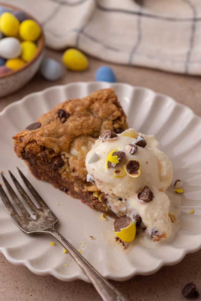 cadbury mini egg skillet cookie slice on a plate with ice cream and a fork