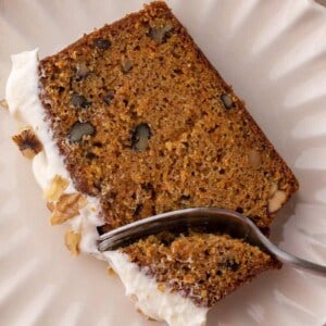 a slice of the carrot cake loaf cake recipe getting a piece taken out