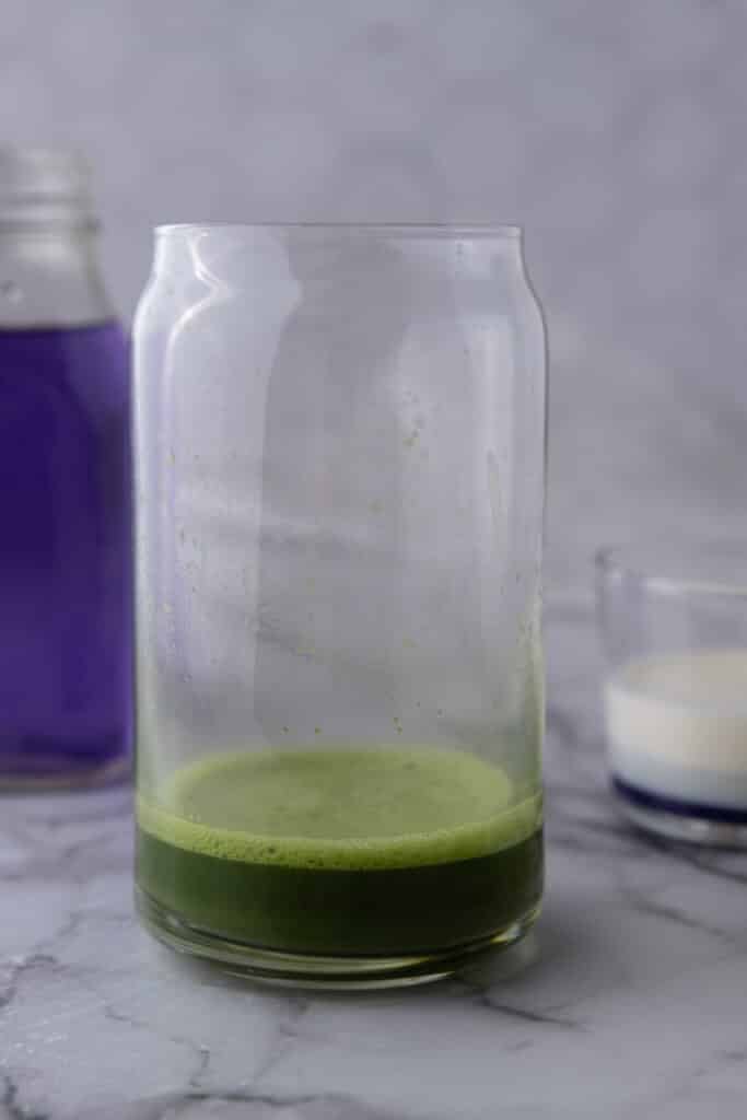 green tea powder and hot water in a glass