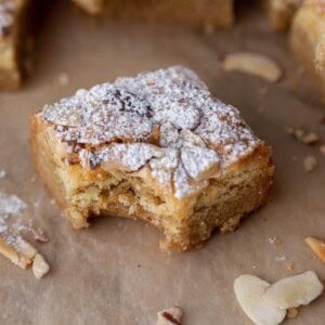 a square of almond croissant blondies with a bite taken out of it
