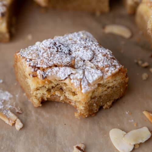 a square of almond croissant blondies with a bite taken out of it