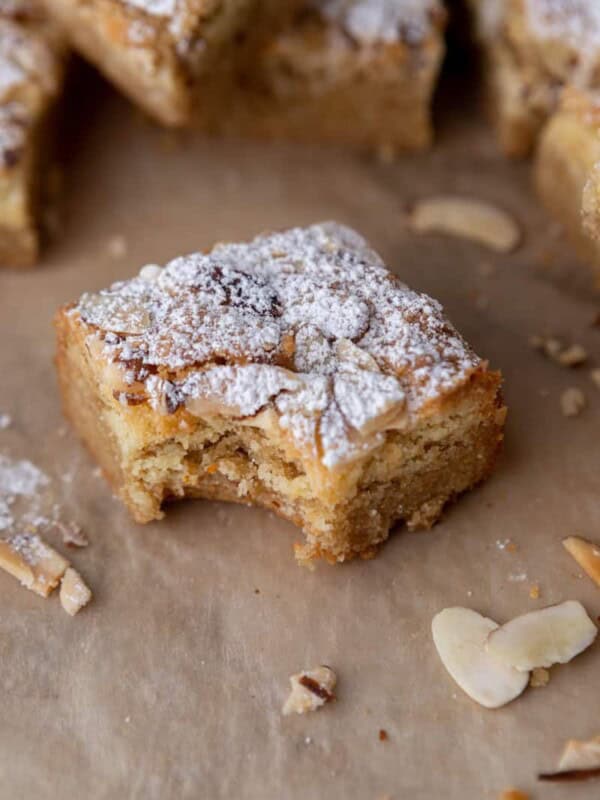 a square of almond croissant blondies with a bite taken out of it