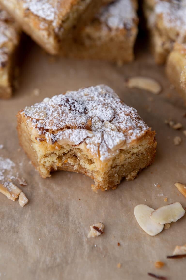 a square of almond croissant blondies with a bite taken out of it