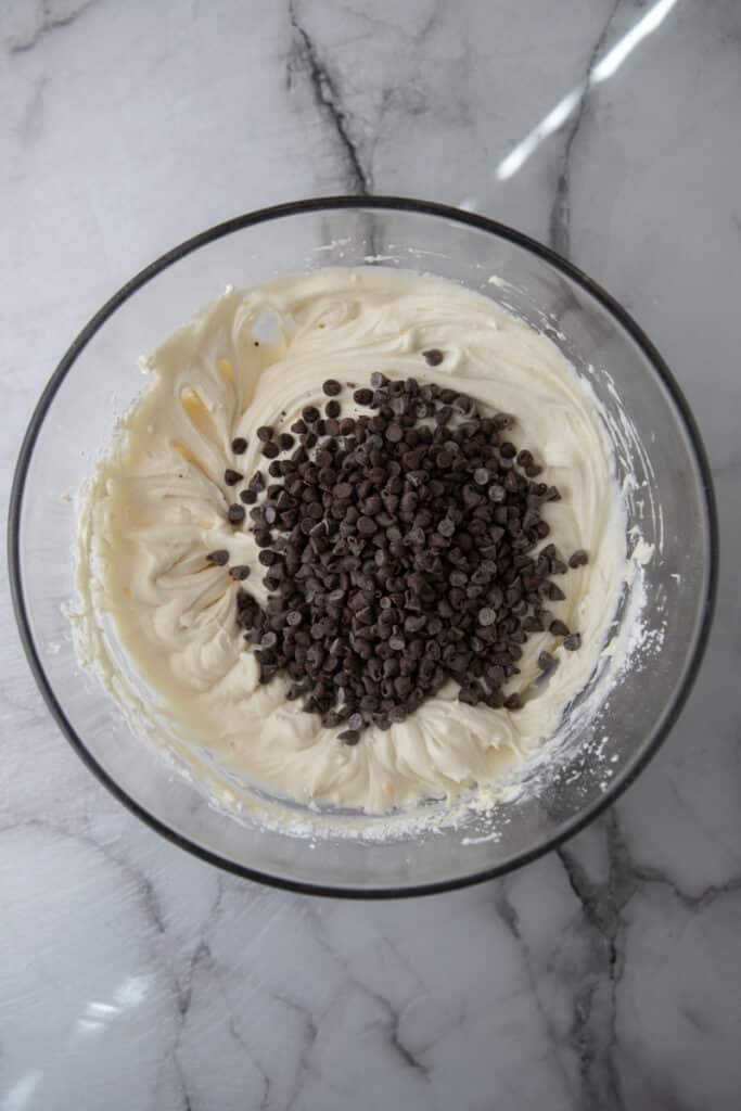 chocolate chips on top of mixed cream in a bowl
