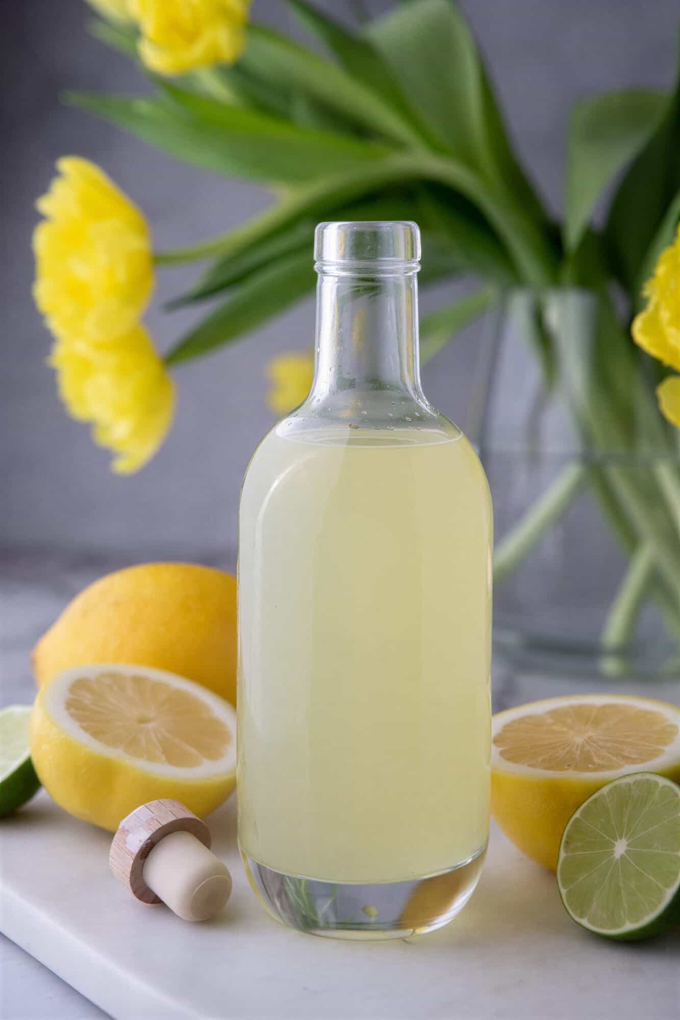 homemade lemon sour mix in a bottle on a table.