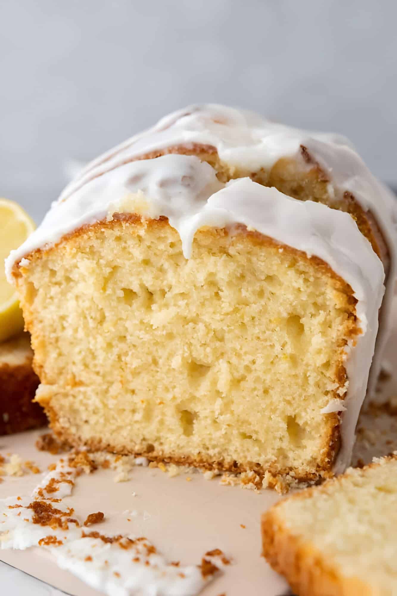 A finished whole lemon blender cake loaf covered in a thick white lemon glaze.