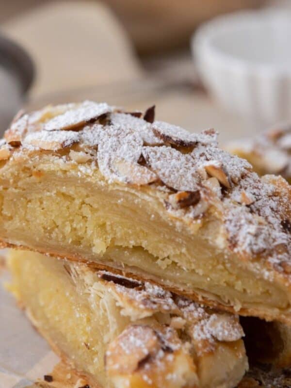 Two pieces of braided almond croissant Danish stacked on top of each other.