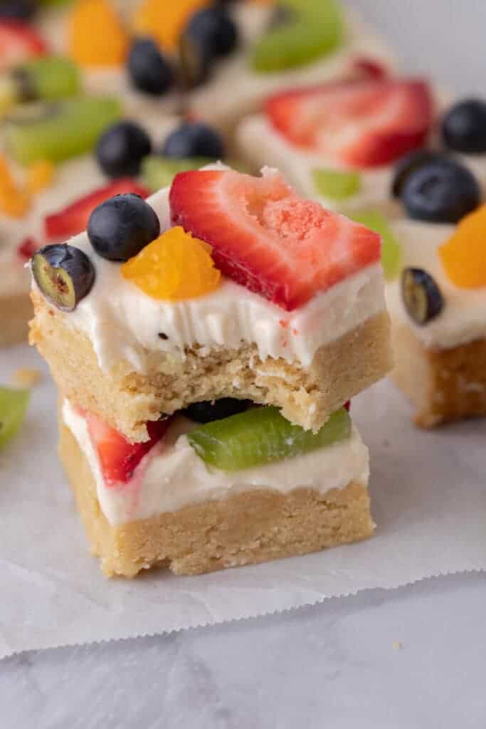 two squares from the sugar cookie fruit pizza bars recipe stacked on top of each other