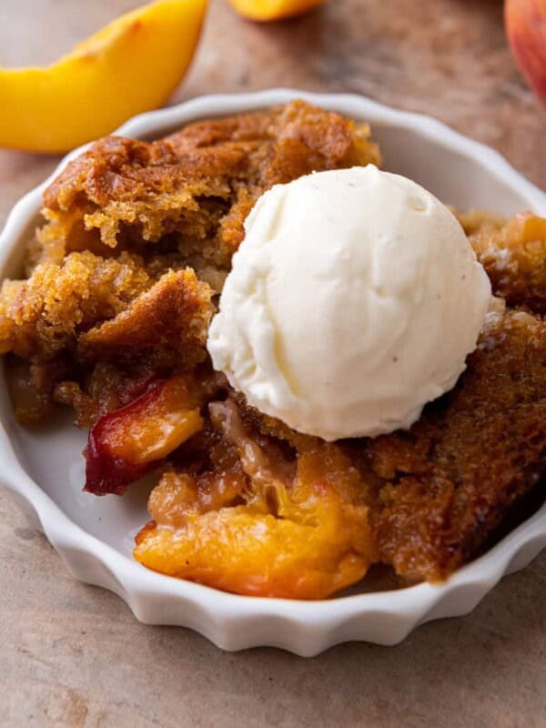 old fashioned peach cobbler recipe on a plate with ice cream
