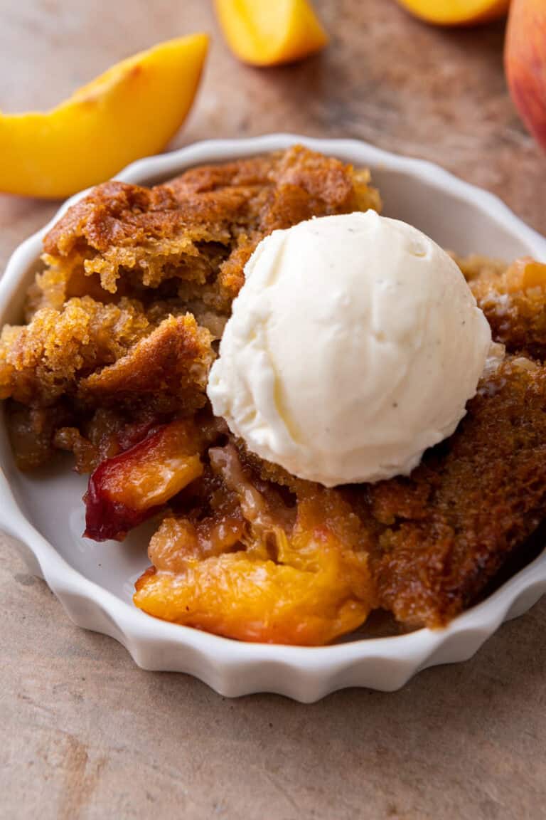 old fashioned peach cobbler recipe on a plate with ice cream