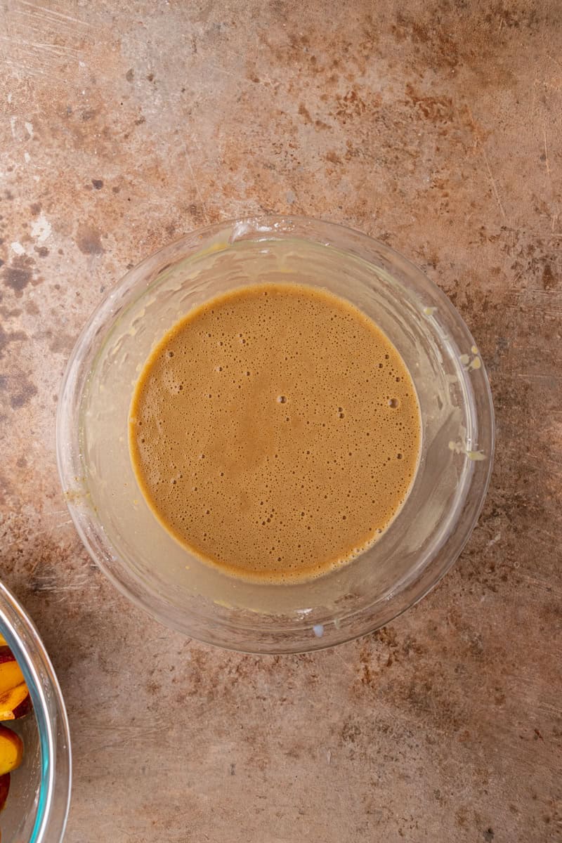 Smooth peach cobbler batter mixed in a bowl.
