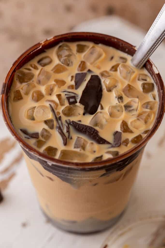 Overhead view of cracking latte with ice nuggets