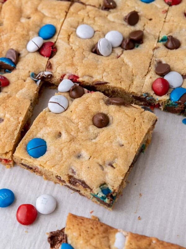 Patriotic M&M blondies cut into squares with red, white, and blue M&M's and chocolate chips.