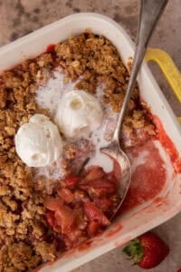 strawberry rhubarb crisp recipe in a baking dish with a spoon