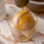 viral olive oil caramel recipe being drizzled over ice cream in a cup with a spoon.