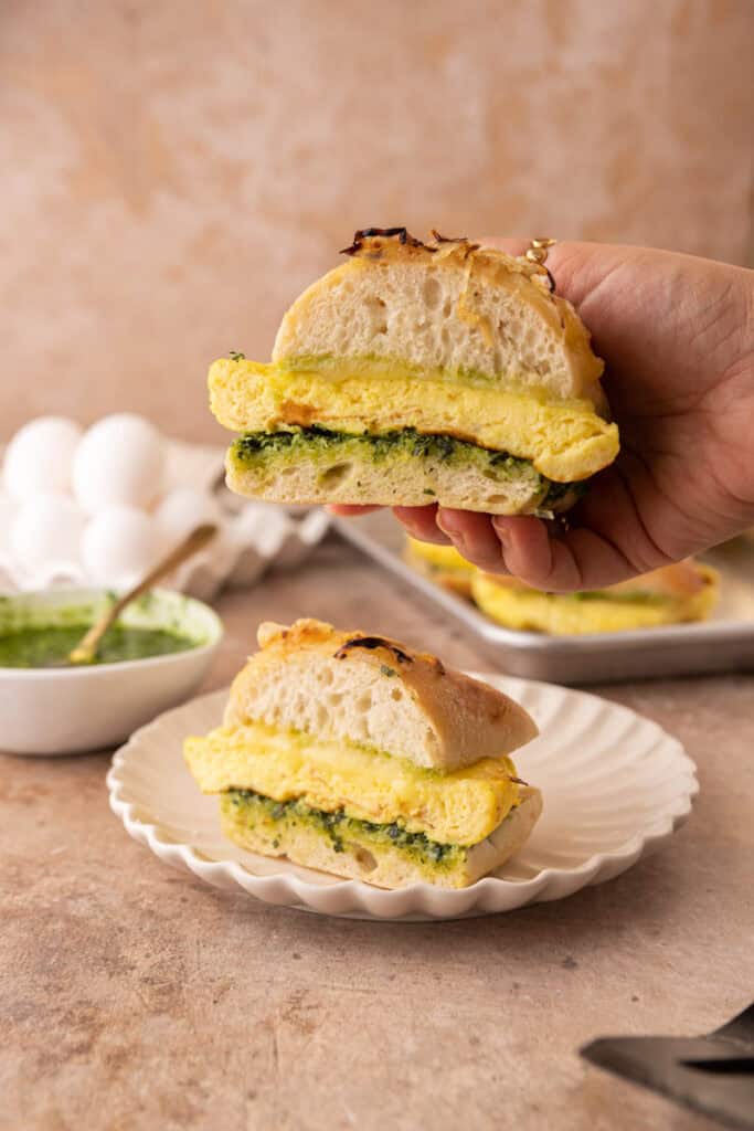 Starbucks Egg Kale Pesto Mozzarella Sandwich recipe being held up by a hand