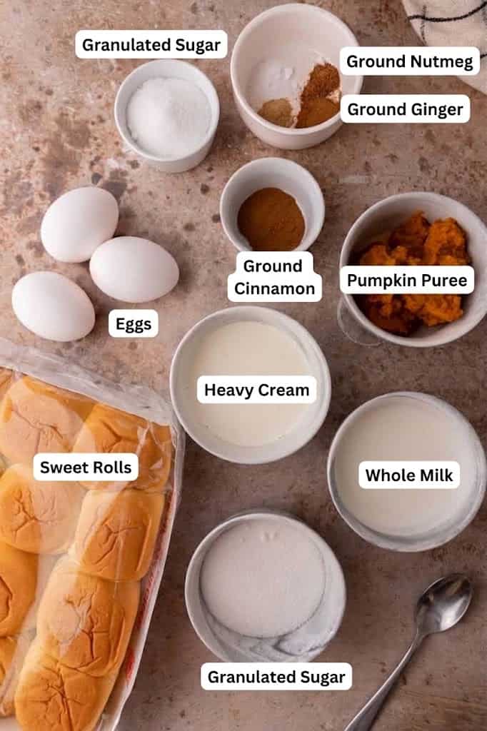Labeled ingredients for Hawaiian roll pumpkin French toast including sweet rolls, pumpkin puree, eggs, cream and spices.