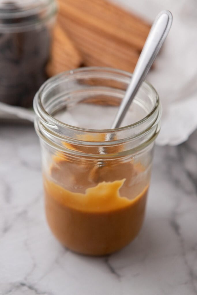 melted candy in a cup being stirred by a spoon