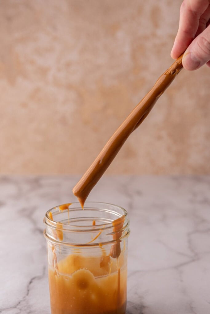 stick being dipped into the melted candy