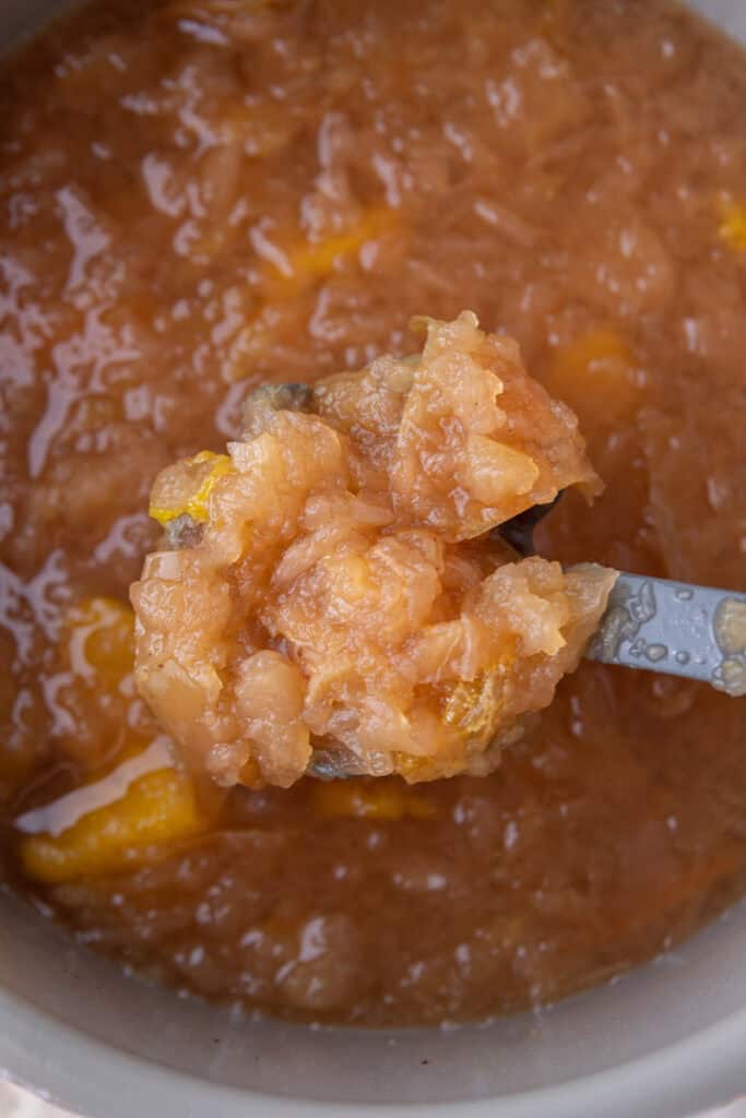 cooked fruit in a pot getting scooped