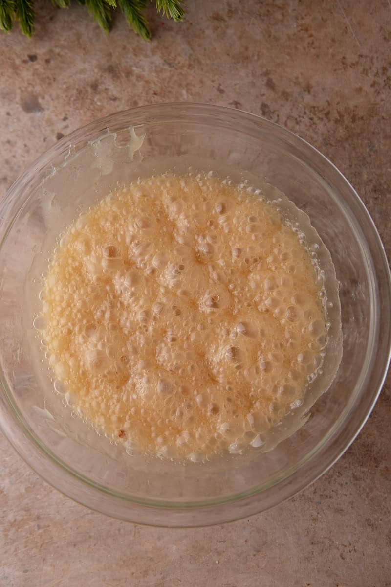 Peanut mixture bubbling in a glass bowl after the second round in the microwave.