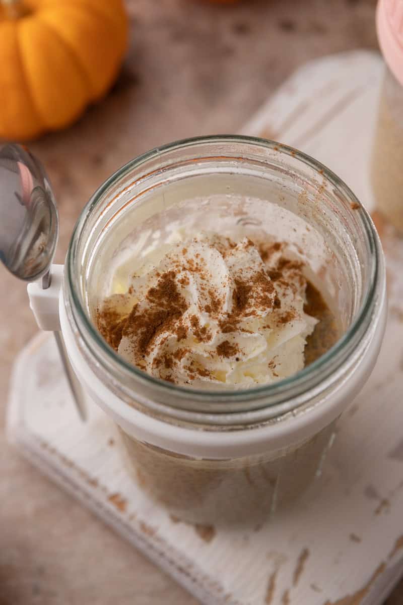 Set pumpkin chia pudding in a jar topped with whipped cream and a dusting of cinnamon.
