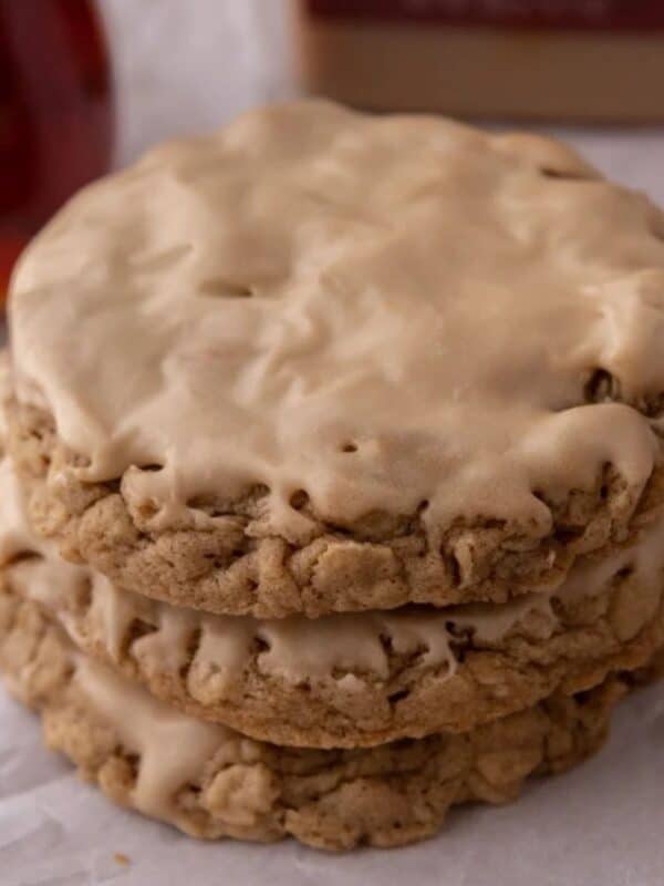 three maple glazed oatmeal cookies stacked on top of each other.