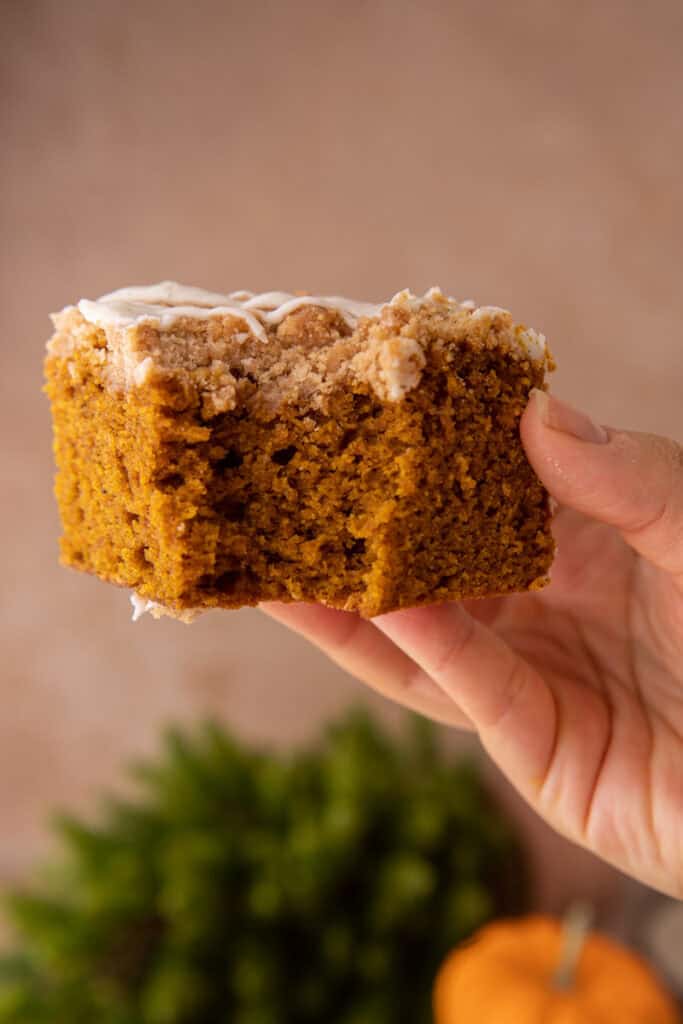 pumpkin coffee cake recipe being held up by a hand