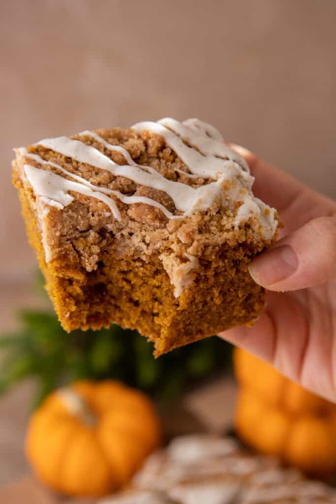 pumpkin coffee cake recipe being held up by a hand