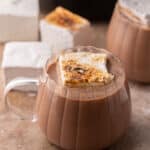 hot cocoa in a crock pot in a glass with a marshmallow