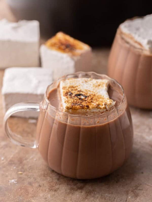 hot cocoa in a crock pot in a glass with a marshmallow