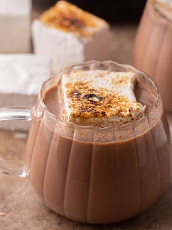 hot cocoa in a crock pot in a glass with a marshmallow