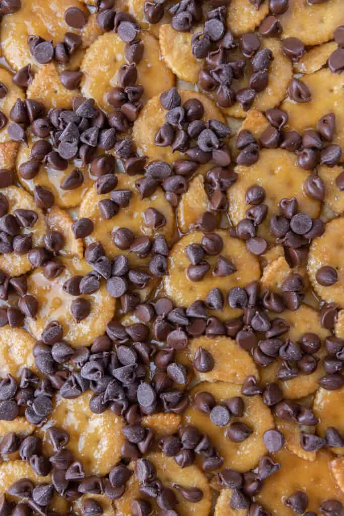 Layer of Christmas crack made with Ritz crackers, caramel, and chocolate chips before melting.
