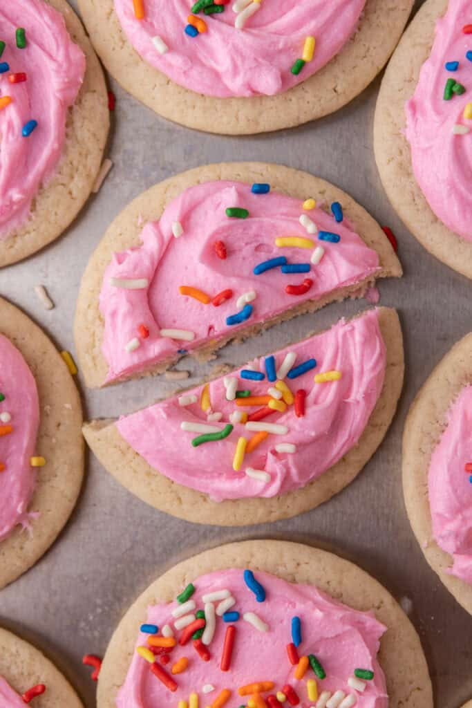 Soft frosted sour cream sugar cookies sliced in half to show texture