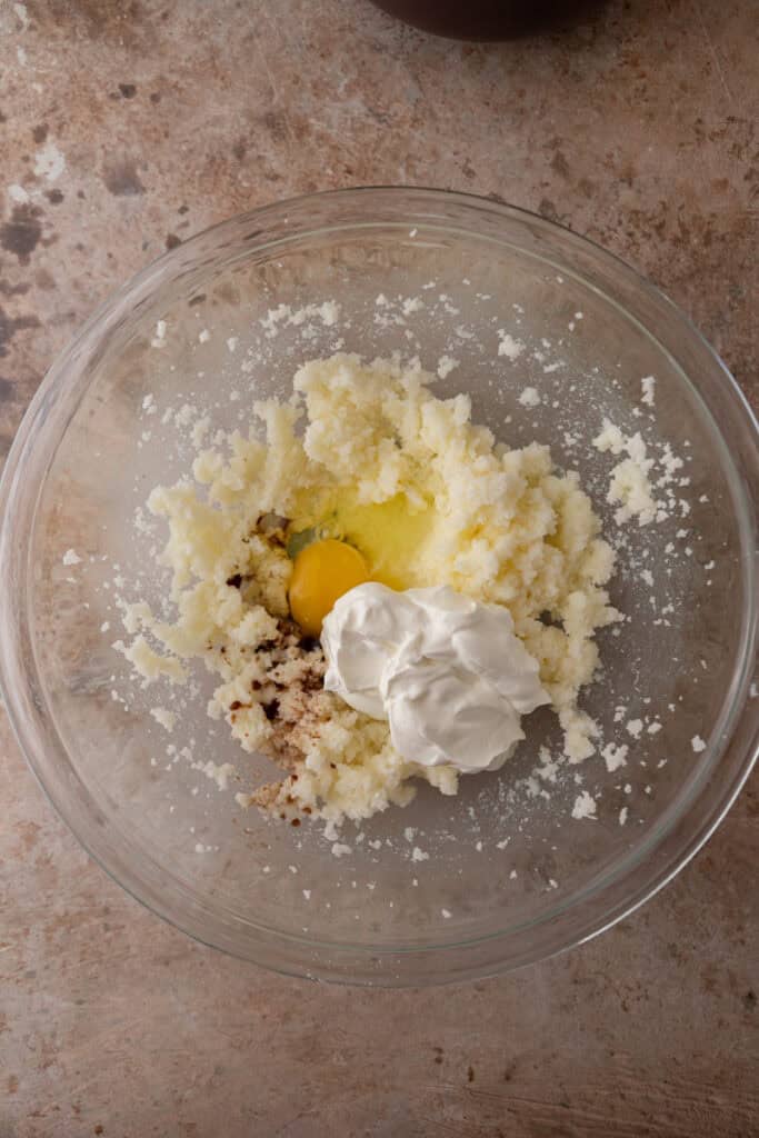 Butter, sugar, sour cream, egg, and vanilla extract in a mixing bowl.