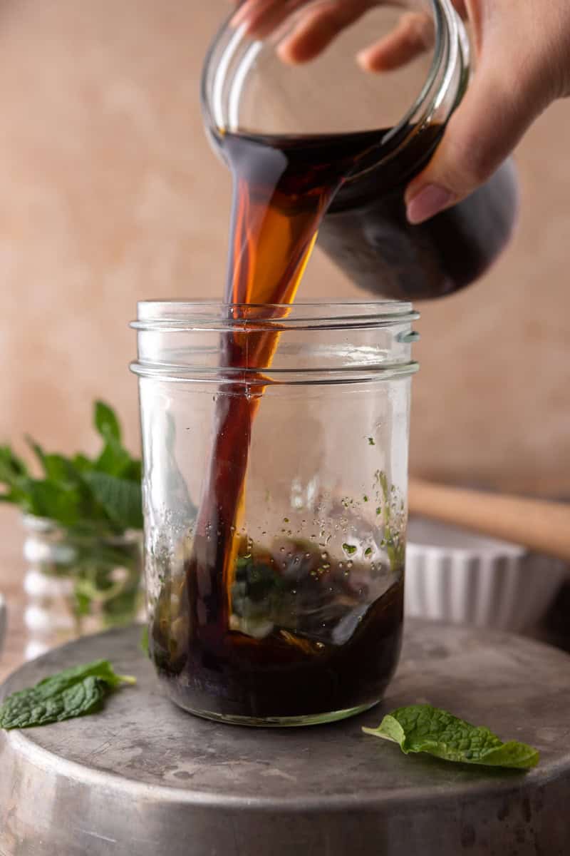 Cold brew coffee poured into the mason jar over the minty brown sugar syrup.
