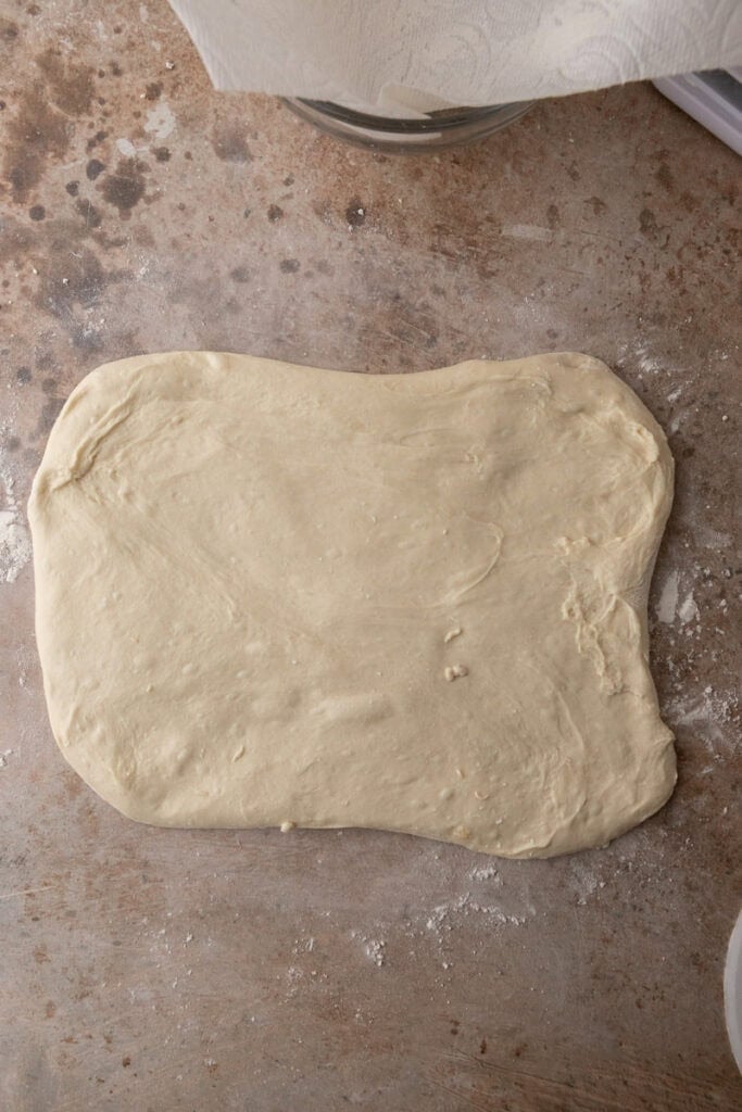 stretched out dough on a floured surface