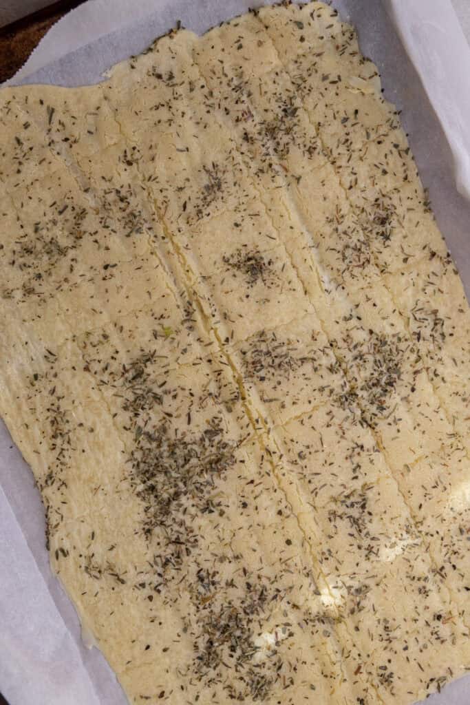 seasoned dough with score marks on baking sheet